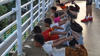 Sejumlah anak berolah raga di Jembatan Penyeberangan Orang (JPO) Kawasan Gunung Sahari, Jakarta, Rabu (11/11/2020).  [ANTARA FOTO/Wahyu Putro]