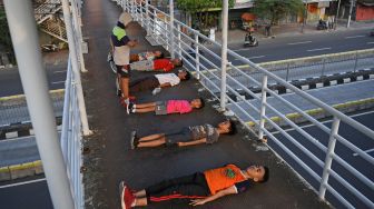 Sejumlah anak berolah raga di Jembatan Penyeberangan Orang (JPO) Kawasan Gunung Sahari, Jakarta, Rabu (11/11/2020).  [ANTARA FOTO/Wahyu Putro]