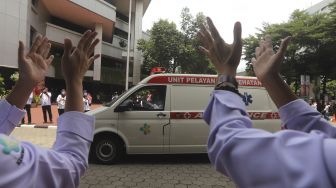 Sejumlah karyawan Kementerian Kesehatan melakukan tepuk tangan secara bersama di depan Gedung Kementerian Kesehatan Republik Indonesia, Jakarta, Kamis (12/11/2020). [Suara.com/Angga Budhiyanto]