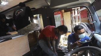 Pekerja menyelesaikan modifikasi mobil campervan di Bengkel Impro Campervan, Depok, Jawa Barat, Jumat (13/11/2020). [Suara.com/Angga Budhiyanto]