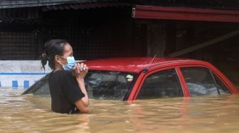 Warga menerobos banjir akibat Topan Vamco,  di Manila, Filipina, Kamis (12/11/2020).  [Ted ALJIBE / AFP]