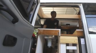 Pekerja menyelesaikan modifikasi mobil campervan di Bengkel Impro Campervan, Depok, Jawa Barat, Jumat (13/11/2020). [Suara.com/Angga Budhiyanto]