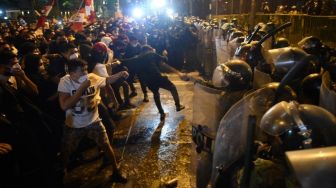 Demonstran bentrok dengan polisi saat melakukan aksi terkait pemakzulan Presiden Martin Vizcarra di Lima, Peru, Kamis (12/11/2020). Kongres Peru, Senin (9/11), memilih untuk melengserkan Presiden Martin Vizcarra dalam sidang pemakzulan atas tuduhan korupsi. Hasil sidang itu merupakan upaya kedua dalam beberapa bulan untuk menurunkan sang presiden dari kursi jabatannya atas tuduhan bahwa ia menerima suap sebagai gubernur dari perusahaan yang memenangkan kontrak pekerjaan umum. ERNESTO BENAVIDES / AFP