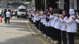 Sejumlah karyawan Kementerian Kesehatan melakukan tepuk tangan secara bersama di depan Gedung Kementerian Kesehatan Republik Indonesia, Jakarta, Kamis (12/11/2020). Memperingati Hari Kesehatan Nasional ke-56, Kementerian Kesehatan Republik Indonesia mengajak seluruh elemen masyarakat yang peduli terhadap pencegahan dan penanganan COVID-19 di Indonesia untuk melakukan tepuk tangan secara bersama selama 56 detik.

Gerakan tersebut juga sebagai penghargaan kepada tenaga kesehatan yang telah berjuang dan masyarakat yang telah melaksanakan protokol kesehatan untuk mencegah penyebaran COVID-19. [Suara.com/Angga Budhiyanto]