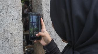 Warga mengabadikan momen pernikahan Komedian Sule dengan Nathalie Holscher dari sela - sela dinding di Jatisampurna, Bekasi, Jawa Barat, Minggu (15/11). [Suara.com/Alfian Winanto] 