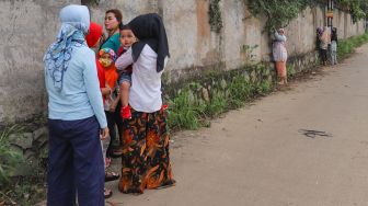 Warga melihat momen pernikahan Komedian Sule dengan Nathalie Holscher dari sela - sela dinding di Jatisampurna, Bekasi, Jawa Barat, Minggu (15/11). [Suara.com/Alfian Winanto] 