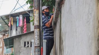 Warga memanjat dinding untuk melihat momen pernikahan Komedian Sule dengan Nathalie Holscher di Jatisampurna, Bekasi, Jawa Barat, Minggu (15/11). [Suara.com/Alfian Winanto] 