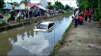 Sebuah Mobil Terios PutihTerjungkal di Tengah Irigasi