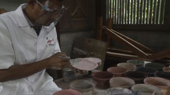 Pekerja menyelesaikan produksi keramik hias di Studio Workshop Rumah Keramik F Widayanto, Tanah Baru, Beji, Kota Depok, Jawa Barat, Rabu (18/11/2020). [Suara.com/Angga Budhiyanto]