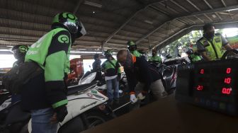 Pengemudi ojek online melakukan uji emisi kendaraan bermotor di Kantor Dinas Lingkungan Hidup DKI Jakarta, Kramat Jati, Jakarta, Kamis (19/11/2020). [Suara.com/Angga Budhiyanto]