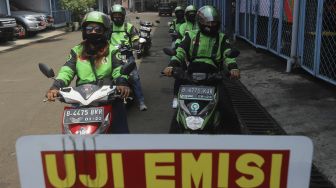 Sejumlah pengemudi ojek online mengantre untuk melakukan uji emisi kendaraan bermotor di Kantor Dinas Lingkungan Hidup DKI Jakarta, Kramat Jati, Jakarta, Kamis (19/11/2020). [Suara.com/Angga Budhiyanto]