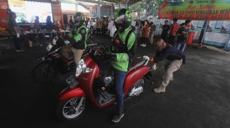 Pengemudi ojek online melakukan uji emisi kendaraan bermotor di Kantor Dinas Lingkungan Hidup DKI Jakarta, Kramat Jati, Jakarta, Kamis (19/11/2020). [Suara.com/Angga Budhiyanto]