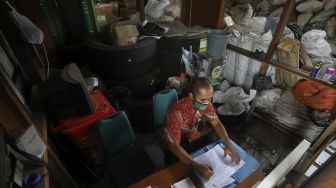 Petugas mencatat limbah elektronik (e-waste) dan limbah B3 (bahan beracun dan berbahaya) yang berada di gudang penyimpanan limbah e-waste dan limbah B3 Dinas Lingkungan Hidup DKI Jakarta, Kramat Jati, Jakarta, Kamis (19/11/2020). [Suara.com/Angga Budhiyanto]