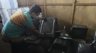 Petugas memeriksa limbah elektronik (e-waste) di gudang penyimpanan limbah e-waste dan limbah B3 Dinas Lingkungan Hidup DKI Jakarta, Kramat Jati, Jakarta, Kamis (19/11/2020). [Suara.com/Angga Budhiyanto]