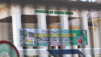 Seorang pegawai berjalan di dalam gedung Pengadilan Negeri Kediri Kelas 1B yang ditutup sementara di Kota Kediri, Jawa Timur, Kamis (19/11/2020).  [ANTARA FOTO/Prasetia Fauzani]