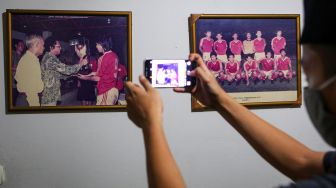 Seorang kerabat mengambil gambar mantan pemain Timnas sepak bola Indonesia Ricky Yacobi yang dipajang di rumah duka di Pondok Ranji, Kota Tangerang Selatan, Banten, Sabtu (21/11/2020). [ANTARA FOTO/Fauzan]