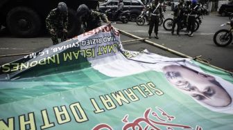 Prajurit TNI menurunkan baliho bergambar Habib Rizieq Shihab saat patroli keamanan di Petamburan, Jakarta, Jumat (20/11/2020). Sebanyak 500 personel gabungan dari TNI dikerahkan untuk menertibkan spanduk ataupun baliho yang tidak memiliki izin di wilayah yang berada di bawah pengamanan Kodam Jaya/Jayakarta. [ANTARA FOTO/Aprillio Akbar]