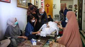 Sejumlah kerabat dan anggota keluarga membacakan doa di dekat jenazah mantan pemain Timnas sepak bola Indonesia Ricky Yacobi di rumah duka di Pondok Ranji, Kota Tangerang Selatan, Banten, Sabtu (21/11/2020).   [ANTARA FOTO/Fauzan]