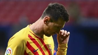 Penyerang Barcelona Lionel Messi bereaksi setelah kehilangan peluang gol selama pertandingan sepak bola Liga Spanyol antara Club Atletico de Madrid melawan FC Barcelona di stadion Wanda Metropolitano, Madrid, pada (21/11/2020). [GABRIEL BOUYS / AFP]