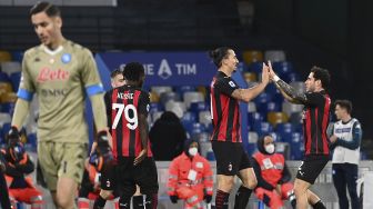 Penyerang AC Milan Zlatan Ibrahimovic (tengah) merayakan gol keduanya bersama bek AC Milan Davide Calabria selama pertandingan sepak bola seri A Italia Napoli vs AC Milan di stadion San Paolo, Naples pada (22/11/2020). [ANDREAS SOLARO / AFP]