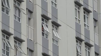 Pasien mengintip suasana luar gedung dari balik jendela ruang perawatan di Rumah Sakit Darurat COVID-19 Wisma Atlet Kemayoran, Jakarta, Senin (23/11/2020). [ANTARA FOTO/Aditya Pradana Putra]