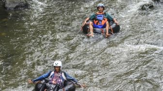 Pengunjung menikmati derasnya aliran Sungai Cikalang menggunakan river tubing di Purbaratu, Kota Tasikmalaya, Jawa Barat, Rabu (25/11/2020). [ANTARA FOTO/Adeng Bustomi]