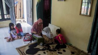 Guru memberikan bimbingan belajar kepada siswa PAUD Pelangi di rumahnya di Kampung Kanaga, Lebak, Banten, Rabu (25/11/2020).  [ANTARA FOTO/Muhammad Bagus Khoirunas]