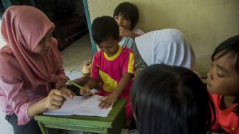 Guru memberikan bimbingan belajar kepada siswa PAUD Pelangi di rumahnya di Kampung Kanaga, Lebak, Banten, Rabu (25/11/2020).  [ANTARA FOTO/Muhammad Bagus Khoirunas]