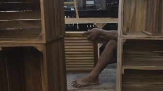 Pekerja menyelesaikan produksi mebel kayu di salah satu workshop furniture di kawasan Kemang, Jakarta, Kamis (26/11/2020). [Suara.com/Angga Budhiyanto]