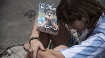 Penggemar menangis di luar kamar mayat tempat jasad mendiang bintang sepak bola Argentina Diego Maradona di San Fernando, provinsi Buenos Aires, Argentina, Rabu (25/11).  [RONALDO SCHEMIDT / AFP]