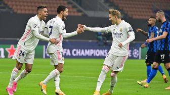 Gelandang Real Madrid Eden Hazard merayakan golnya usai mencetak gol penalti dengan pemain depan Real Madrid Mariano (kiri) dan gelandang Real Madrid Martin Odegaard selama pertandingan sepak bola Grup B Liga Champions Inter Milan melawan Real Madrid  di Stadion Giuseppe-Meazza, Milan, Italia, Kamis (26/11) dini hari WIB. MIGUEL MEDINA / AFP