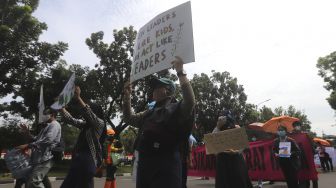 Peserta aksi Asia Climate Rally membawa poster saat menggelar aksi unjuk rasa di depan Balai Kota Jakarta, Jumat (27/11/2020). [Suara.com/Angga Budhiyanto]