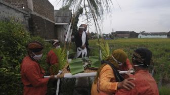 Sejumlah warga dan seniman melakukan prosesi tradisi wiwitan padi di Kayuhan, Sidowayah, Polanharjo, Klaten, Jawa Tengah, Sabtu (28/11/2020). [ANTARA FOTO/Aloysius Jarot Nugroho]