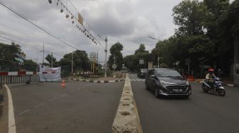 Sejumlah kendaraan bermotor melintas di samping perlintasan sebidang yang sudah ditutup di kawasan Stasiun Palmerah, Jakarta, Minggu (29/11/2020). [Suara.com/Angga Budhiyanto]