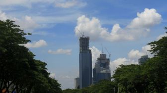 Gedung berlatar belakang awan biru di Jakarta, Rabu (2/12). [Suara.com/Oke Atmaja]
