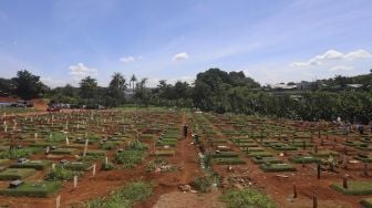 Petugas melintasi area pemakaman khusus COVID-19 di TPU Pondok Ranggon, Jakarta, Rabu (2/12/2020). [Suara.com/Angga Budhiyanto]