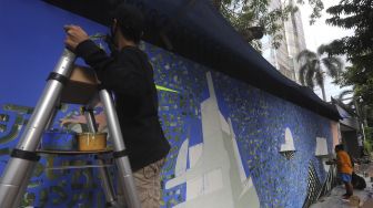 Seniman membuat seni mural berisi "Kampanye Bersihkan Udara di Banyak Kota di Seluruh Dunia" di depan Institut Prancis Indonesia (IFI), Jakarta, Rabu (2/12/2020). [Suara.com/Angga Budhiyanto]