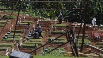 Warga berziarah ke makam keluarganya yang meninggal akibat COVID-19 di TPU Pondok Ranggon, Jakarta, Rabu (2/12/2020). [Suara.com/Angga Budhiyanto]