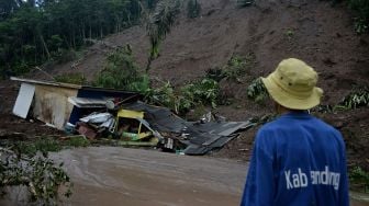 Petugas mengamati rumah yang rusak akibat tanah longsor di Desa Sukamulya, Talegong, Kabupaten Garut, Jawa Barat, Kamis (3/12/2020). [ANTARA FOTO/Candra Yanuarsyah]
