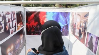 Seorang pengunjung mengamati karya di pameran fotografi Rekam Jakarta 2020 di Thamrin 10, Jakarta Pusat, Sabtu (5/12). [Suara.com/Alfian Winanto]