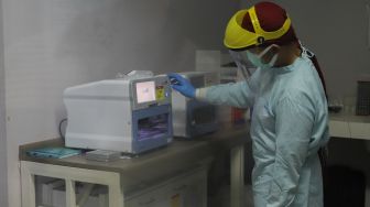 Petugas laboratorium memeriksa sampel hasil swab test Covid-19 di PRVKP FKUI, Jakarta, Senin (7/12/2020). [Suara.com/Alfian Winanto]