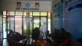 Petugas menyemprotkan cairan disinfektan di kawasan SMP 3 Jekulo, Kudus, Jawa Tengah, Selasa (8/12/2020). [ANTARA FOTO/Yusuf Nugroho]
