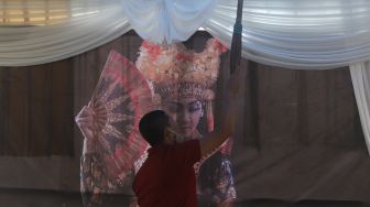 Petugas mempersiapkan Tempat Pemungutan Suara (TPS) dengan nuansa adat Bali di Kampung Benda Barat, Kelurahan Cipayung, Kota Depok, Jawa Barat, Selasa (8/12/2020). [Suara.com/Angga Budhiyanto]