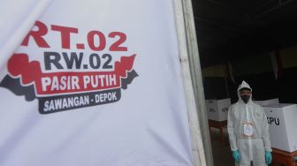 Petugas KPPS mengenakan pakaian hazmat dan Alat Perlindungan Diri (APD) di Tempat Pemungutan Suara (TPS) 13 pada Pilkada Kota Depok 2020 di Pasir Putih, Sawangan, Depok, Jawa Barat, Rabu (9/12/2020). [Suara.com/Angga Budhiyanto]