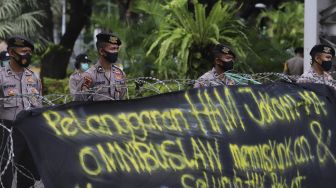 Aparat kepolisian melakukan penjagaan saat sejumlah massa melakukan aksi unjuk rasa di kawasan Patung Kuda Arjuna Wiwaha, Jakarta, Kamis (10/12/2020). [Suara.com/Angga Budhiyanto]