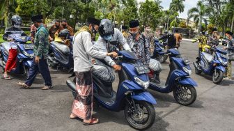 Pengurus Majelis Ulama Indonesia (MUI) memeriksa kendaraannya saat penyerahan bantuan hibah kendaraan di Halaman Pendopo, Kabupaten Ciamis, Jawa Barat, Kamis (10/12/2020).  [ ANTARA FOTO/Adeng Bustomi]