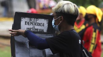 Massa membawa replika makam saat melakukan aksi unjuk rasa di kawasan Patung Kuda Arjuna Wiwaha, Jakarta, Kamis (10/12/2020). [Suara.com/Angga Budhiyanto]