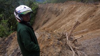 Pengendara motor menunggu pembersihan material longsor, di Bukik Apik, Malalak, Kabupaten Agam, Sumatera Barat, Jumat (11/12/2020). [ANTARA FOTO/Iggoy el Fitra]
