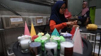 Seorang anak membantu orang tuanya saat mengemas hasil produksi lilin yang telah jadi, di Candi, Ampel, Boyolali, Jawa Tengah, Jumat (11/12/2020). [ANTARA FOTO/Aloysius Jarot Nugroho]
