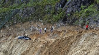 Mobil melintasi jalan yang baru dibuka akibat longsor, di Bukik Apik, Malalak, Kabupaten Agam, Sumatera Barat, Jumat (11/12/2020).  [ANTARA FOTO/Iggoy el Fitra]
